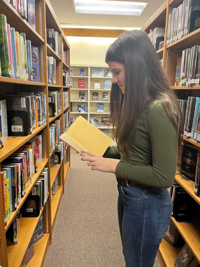 Alyssa Weber browses the aisle for a new book! Photo Courtesy of: Kelli McGee.