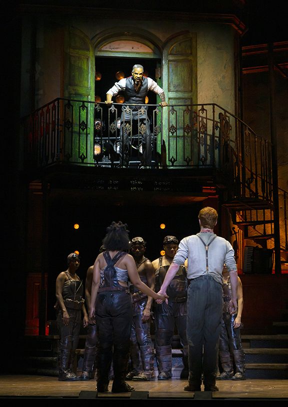 Photo Courtesy of Where Y’At 
Pictured above is Hades interacting with the workers of Hadestown from his balcony. 