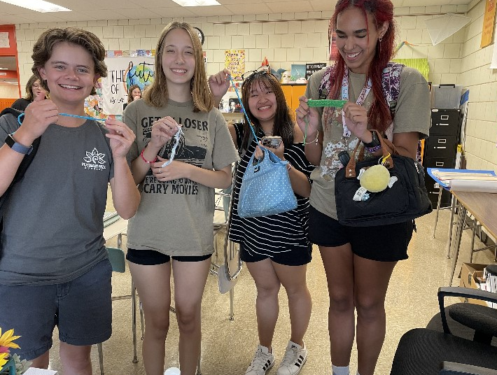 Crocheting Club’s members pose with the very first thing they crocheted. (Photo Courtesy of Aubrey Winter.)