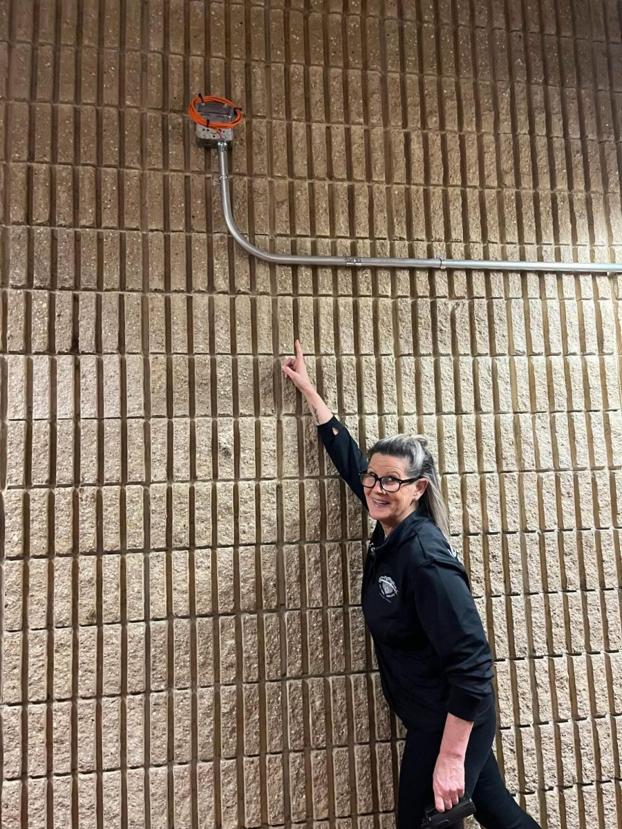 Ms. Graf points out the new wall mount! Photo Courtesy of Arianna Hernandez