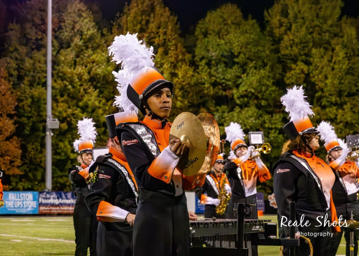 Langston playing the cymbals and marching with the rest of the band. Photo Courtesy of Reale Shots Photography.