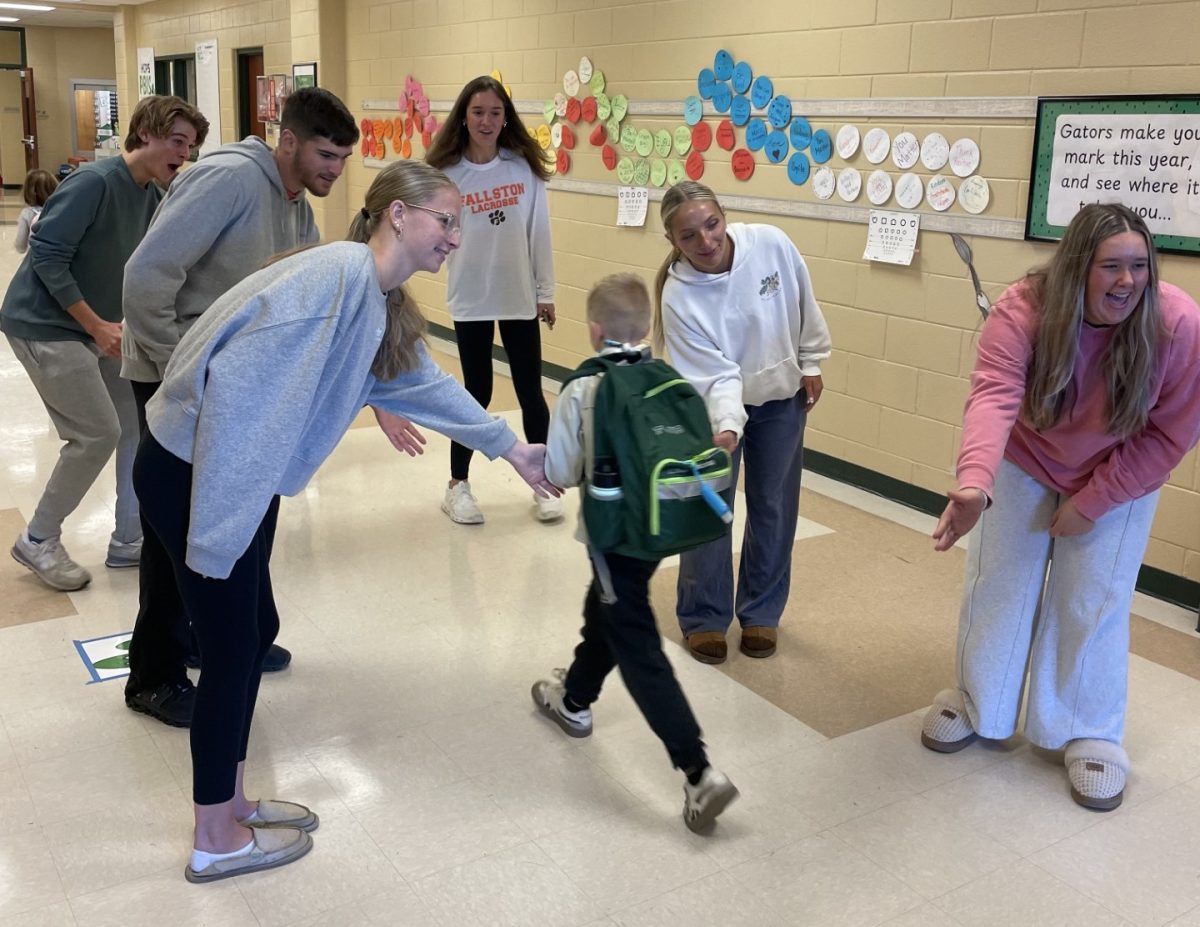 Cougars Care greets Youth’s Benefit Elementary Schoolers with high-fives.  Photo Courtesy of Mrs. Ryan