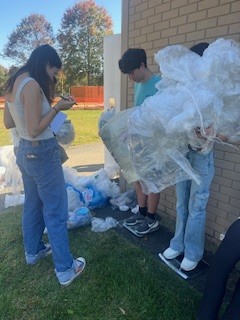 During a Green School club meeting, Kasey Conlon and Emberly Witts, active members of the club, worked together to weigh the progress of the school’s current plastic collection. Photo courtesy of Maddy Burch 