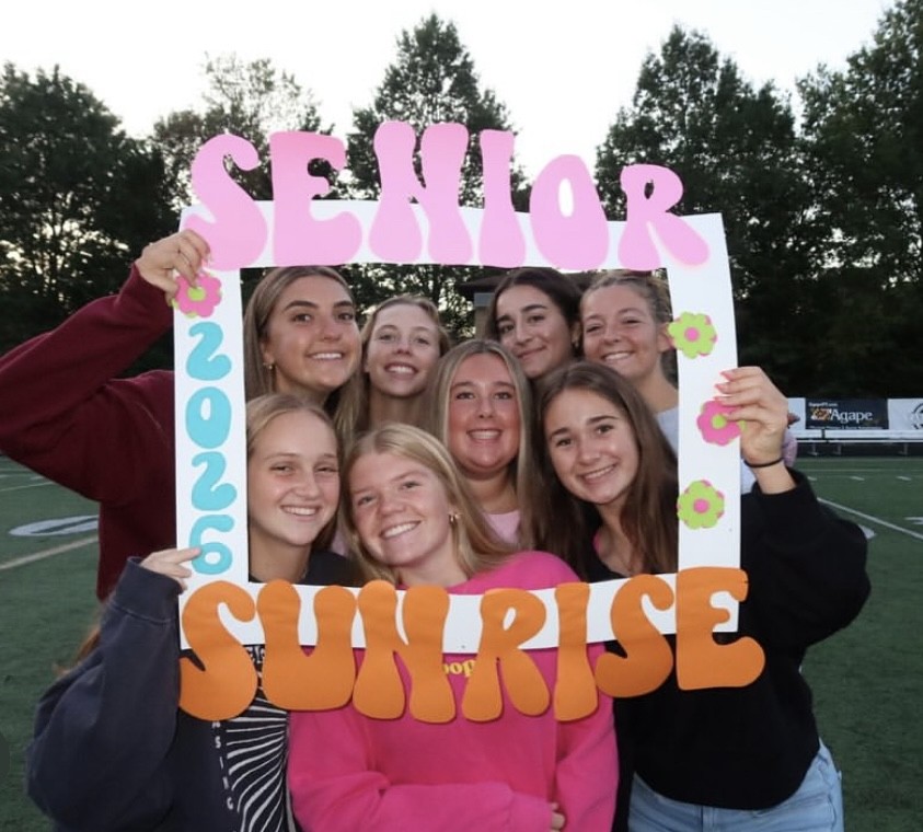 With the sunrise as their backdrop, the Class of 2026 can’t wait for the year ahead. This was one of the many delightful signs students spent making for the sunrise. Pictured left to right are Andrea Dorezas, Maddie Morehead, Phaedra Michaelides, Alexa Wilson, (top row) and Emily Harthausen, Peyton Greiner, Emma Chasan, and Myra Whitely (bottom row). Photo courtesy of Emma Chasan.  