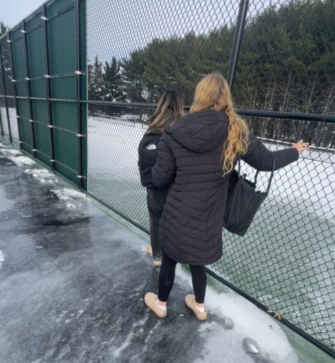 Juniors, Katie Nguyen and Reagan Stevens, hold on to Fallston High School’s tennis court fence on an icy walk to class. Photo Courtesy of Ian Bishoff.